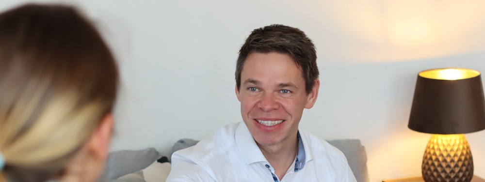 Leadership-Coach Michael Bessel lächelnd im Gespräch mit einer Klientin